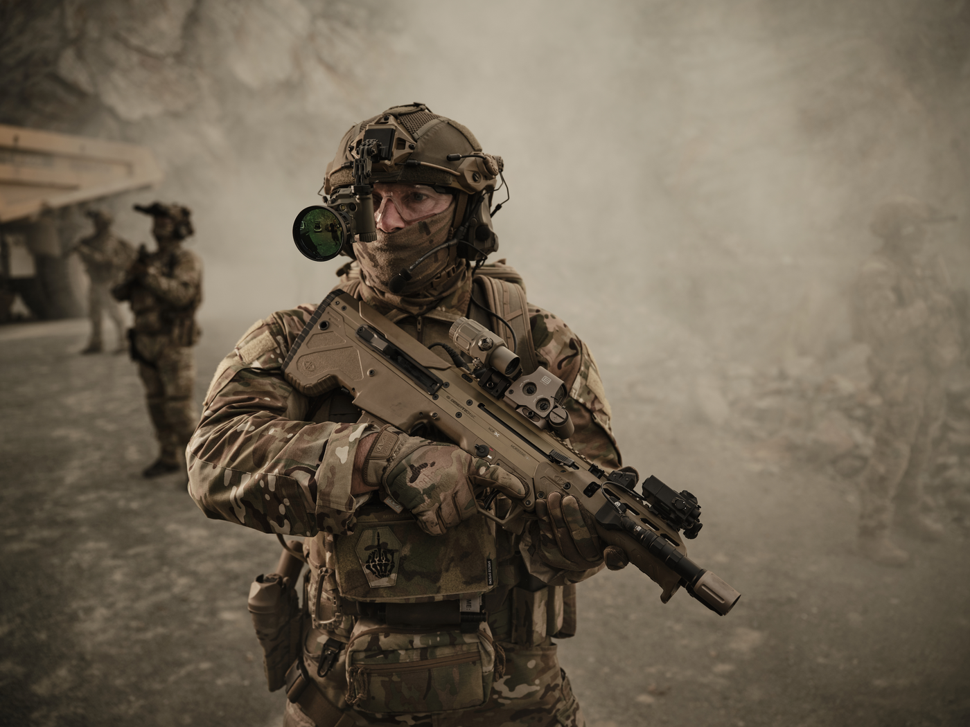 Mehrere Soldaten stehen in einer Staubwolke. Im Vordergrund sieht man, dass eine TILO mit einer Vorsatzlinse am Helm befestigt ist.