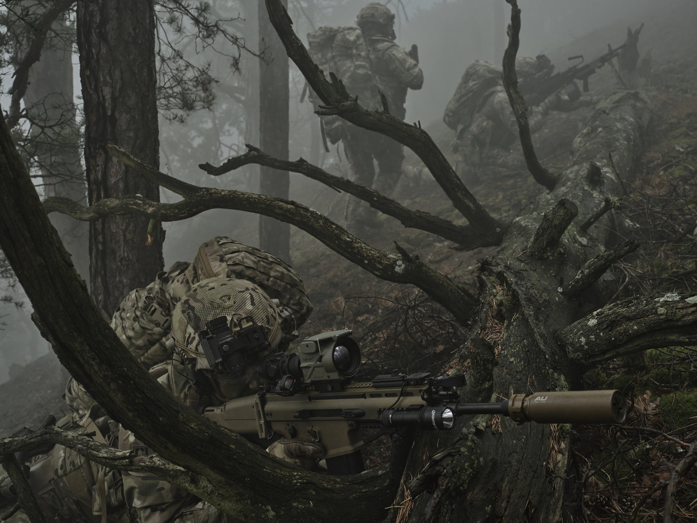 Drei Soldaten in einem nebligen Wald zielen mit einem TigIR hinter einem gefallenen Baumstamm