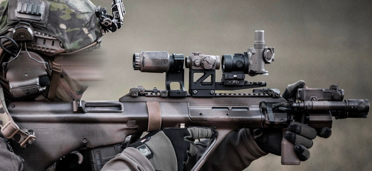 Eine Person in Ausrüstung zielt mit einer TILO und einem Red-Dot-Flipper auf einer Waffe