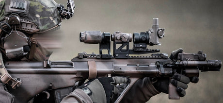 Eine Person in Ausrüstung zielt mit einer TILO und einem Red-Dot-Flipper auf einer Waffe