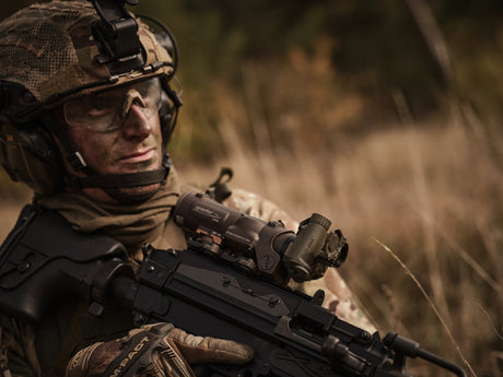 Ein Soldat hält eine Waffe mit einem ELCAN an dem eine TILO montiert ist.